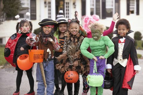 raznolika skupina otrok v jesenskih kostumih in kostumih čarovnic