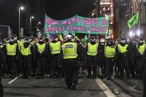 Glasgow, Škotska, november 03 policisti spremljajo protest proti izumrtju pred vrhom cop26, ko je viden transparent, na katerem piše, koliko policistov naj aretira podnebni kaos na 3. novembra 2021 v Glasgowu v Združenem kraljestvu, ko se svetovni voditelji srečajo, da bi razpravljali o podnebnih spremembah na vrhu cop26, so številne skupine za podnebne ukrepe protestirale na ulice resničen napredek, ki ga morajo vlade doseči pri zmanjšanju emisij ogljika, čiščenju oceanov, zmanjšanju porabe fosilnih goriv in drugih vprašanjih v zvezi z globalnim ogrevanjem. Foto: Peter Summersgetty slike