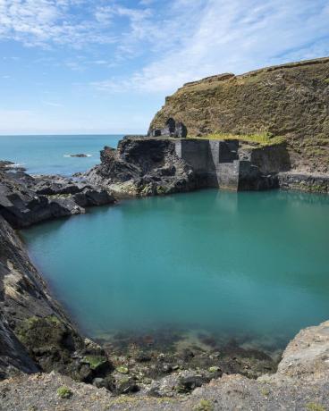 dobro znana značilnost v narodnem parku Pembrokeshire Coast stari kamnolom, ki ga je poplavilo morje, da bi ustvaril temno moder bazen ostanki starih zgradb ob vodi