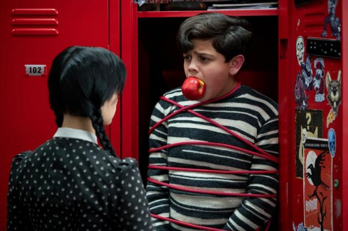 dekle gleda fanta, privezanega v omarici z jabolkom v ustih