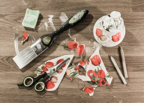 orodja za decoupage na leseni mizi, vključno s čopičem za barvanje, škarjami, svinčniki, gobico in izrezan papir