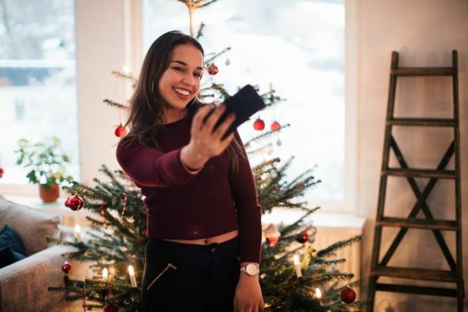ženska, ki posname selfie pred božičnim drevesom