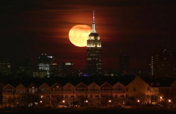 Polna luna vzhaja za Empire State Building v New Yorku