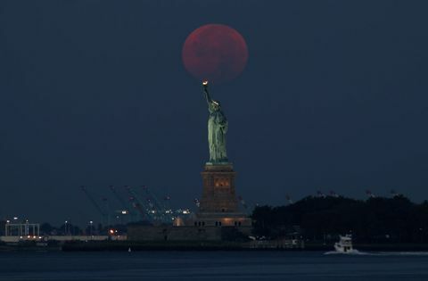 Polna luna stoji za kipom svobode v New Yorku