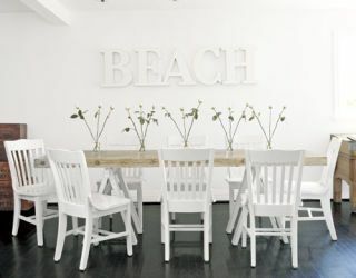 neuradna jedilnica z zložljivimi stoli in plažo z belimi črkami na steni