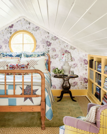 očarljiva podeželska spalnica z leseno posteljo in svetlo vijolično tapeto iz chintza