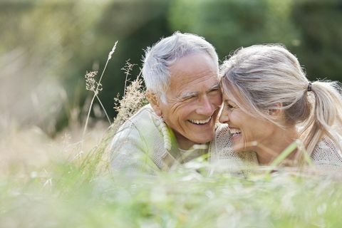 Srečen starejši par, ki sedi v dolgi travi