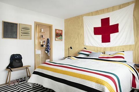 lastnik stanovanja spalnica raili clasen s črtasto odejo in veliko zastavo rdečega križa