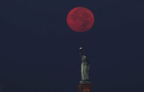 Polna luna stoji za kipom svobode v New Yorku