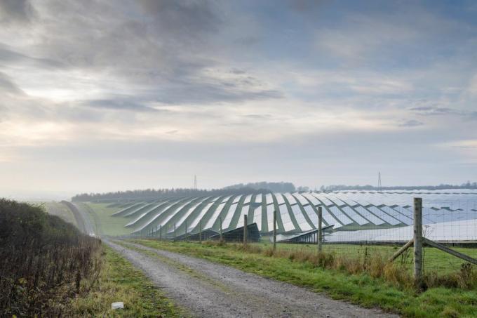 lokacija za pridobivanje sončne energije, ki leži v osrčju angleškega podeželja, ograjena, z ozko makadamsko potjo, ki teče ob njej do kmetijskih zemljišč