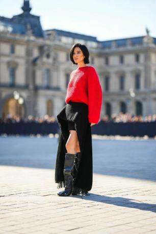 Pariz, Francija, 4. oktober Kelsey Asbille nosi rdeč rebrast volnen prevelik pulover, črno asimetrično dolgo krilo z vlakom Louis Vuitton iz klobučevine, črne svetleče usnjene blok pete, patti kolena škornji visoki škornji znamke Louis Vuitton, zunaj Louis Vuitton, med pariškim tednom mode ženska oblačila pomlad-poletje 2023, 4. oktobra 2022 v Parizu, Francija, fotografija edwarda berthelotgettyja slike