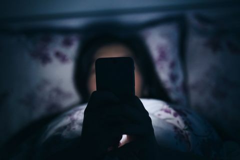 ženska v postelji telefon